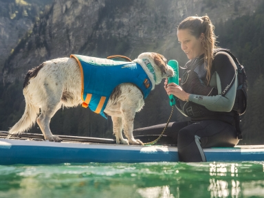 Hund mit Frau auf dem Wasser mit Ruffwear Schwimmweste