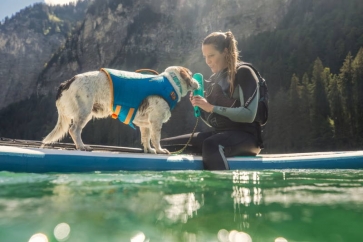 Hund mit Frau auf dem Wasser mit Ruffwear Schwimmweste