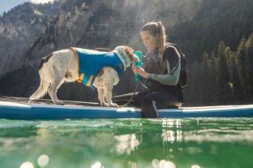 Hund mit Frau auf dem Wasser mit Ruffwear Schwimmweste