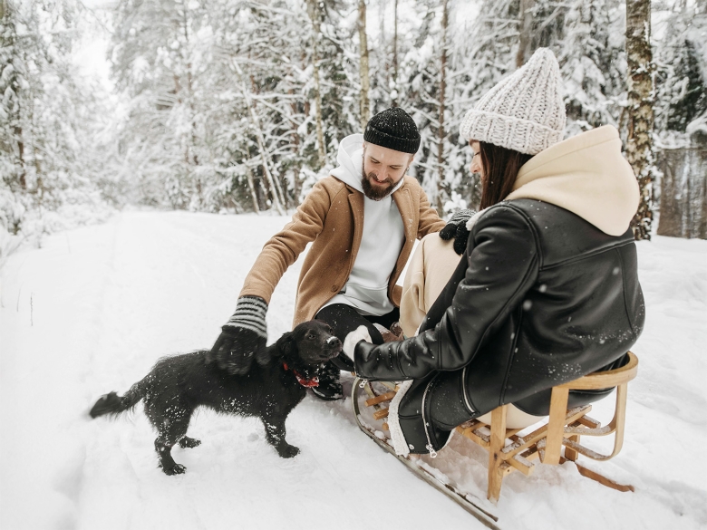 Paar mit Hund im Schnee